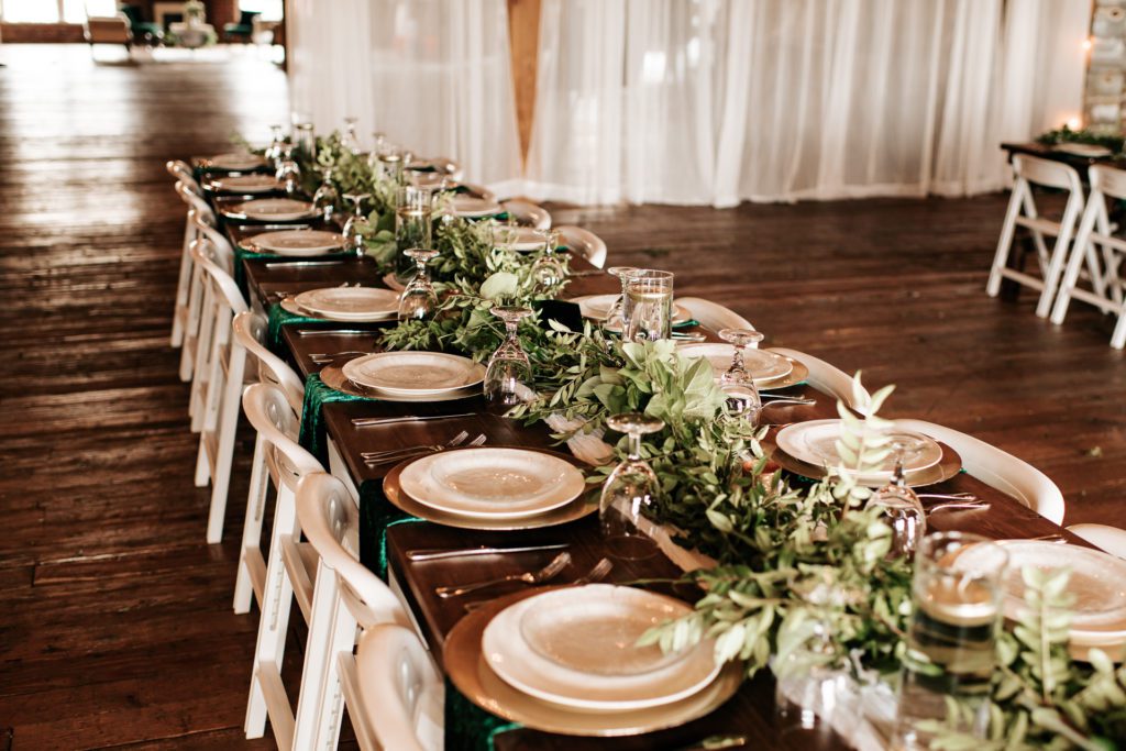 Elegant place settings at a wedding on farmhouse tables