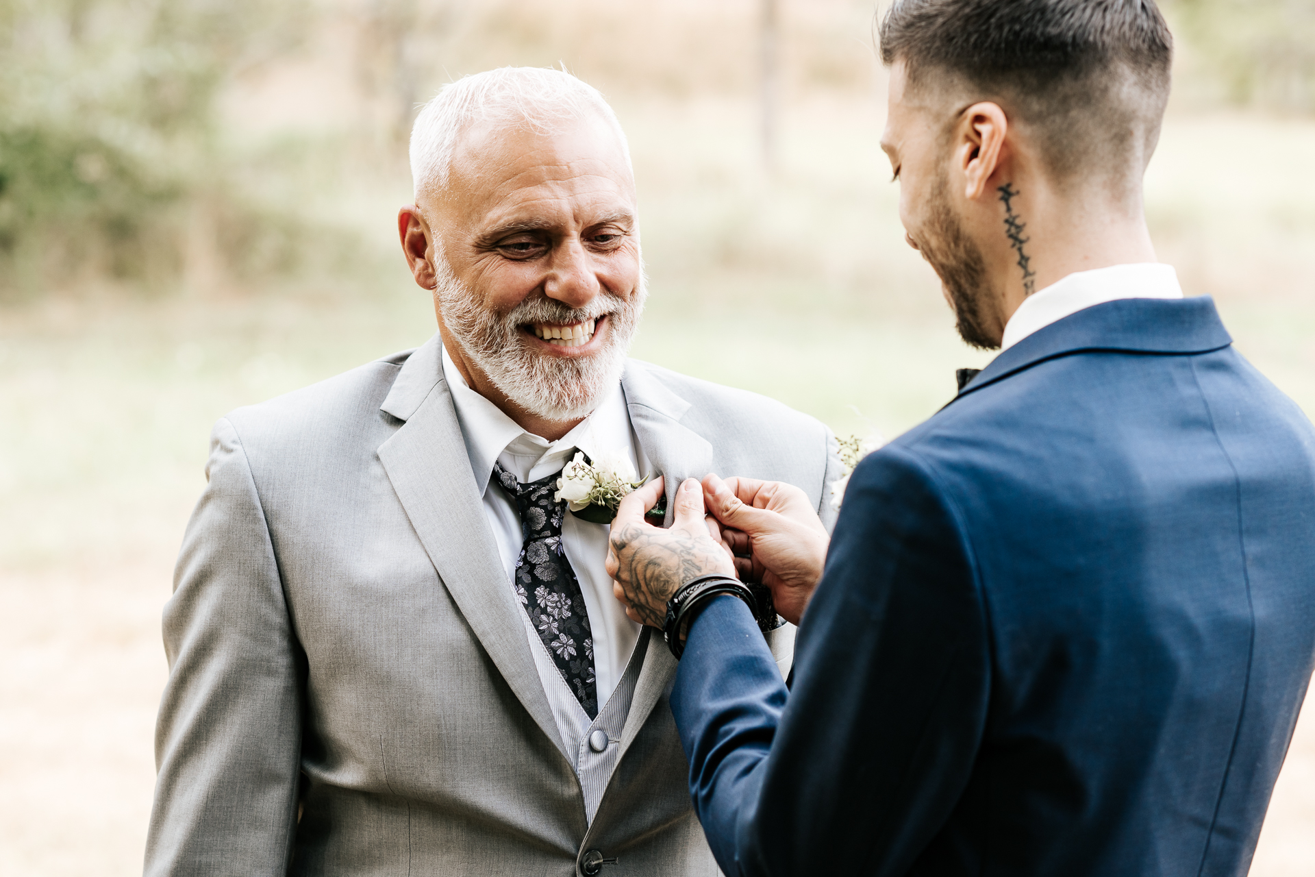 Groom pins Boutonniere on father of the Bride