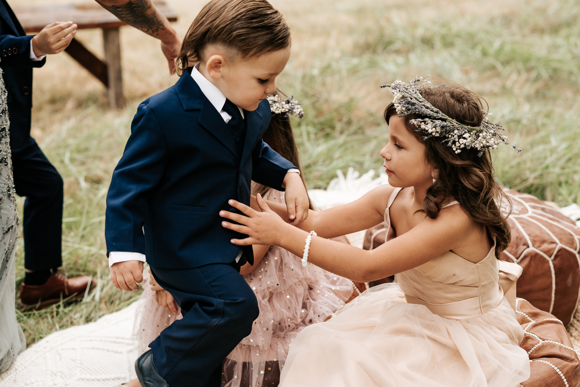 Ring Bearer gets handed off to the flower girl during the ceremony and sits on a pouf