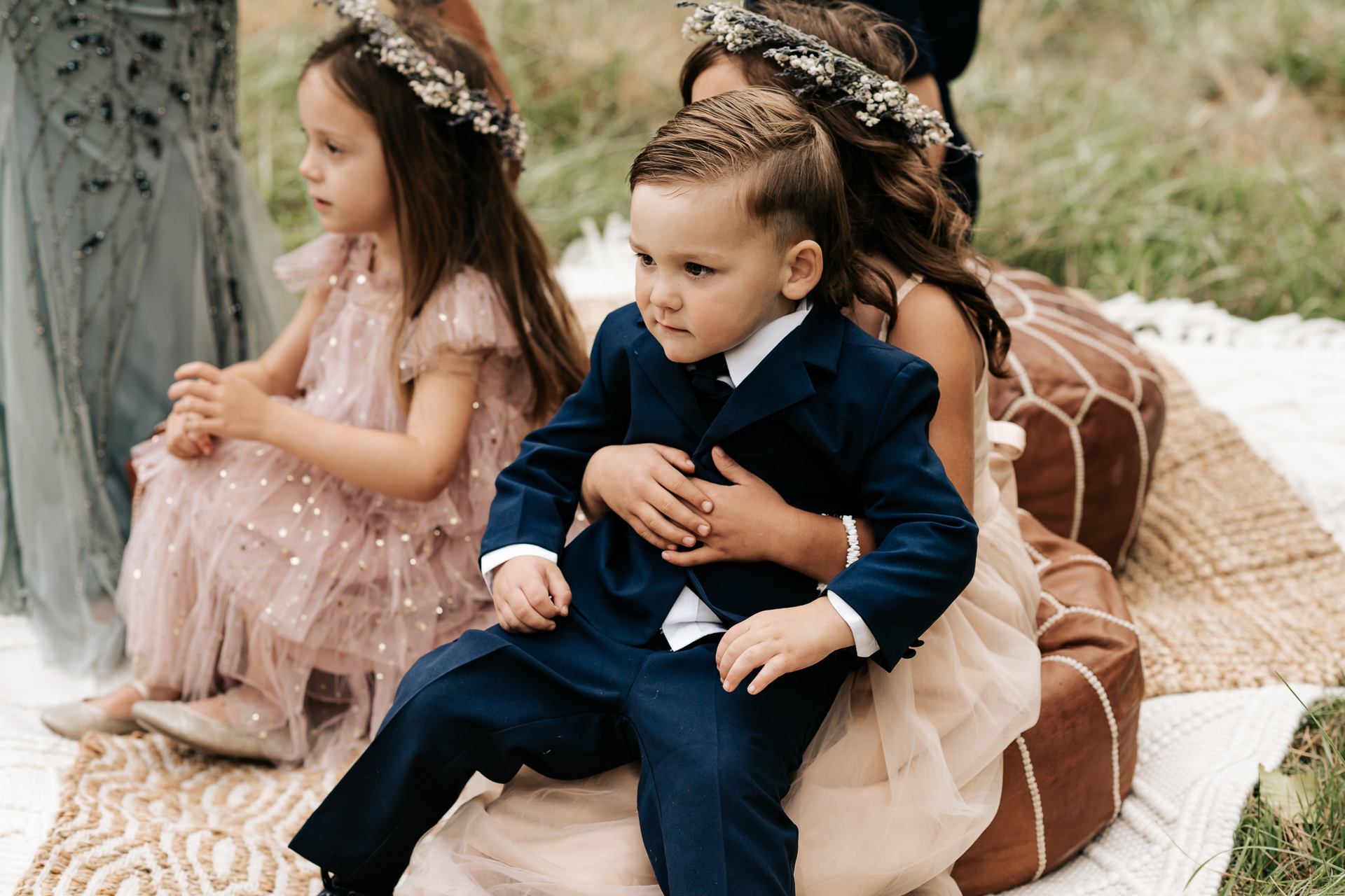 Flower Girls and Ring Bearer Sitting on Poufs at the Wedding Ceremony