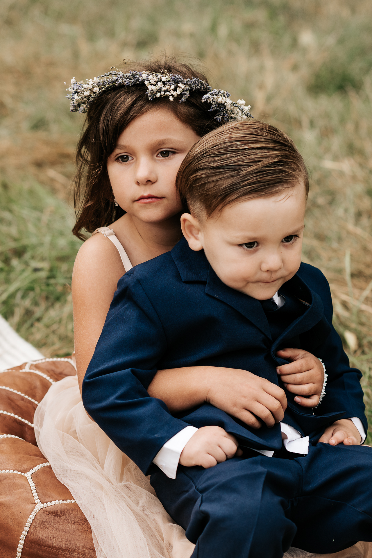 Flower girl and ring bearer sitting at a wedding ceremony together