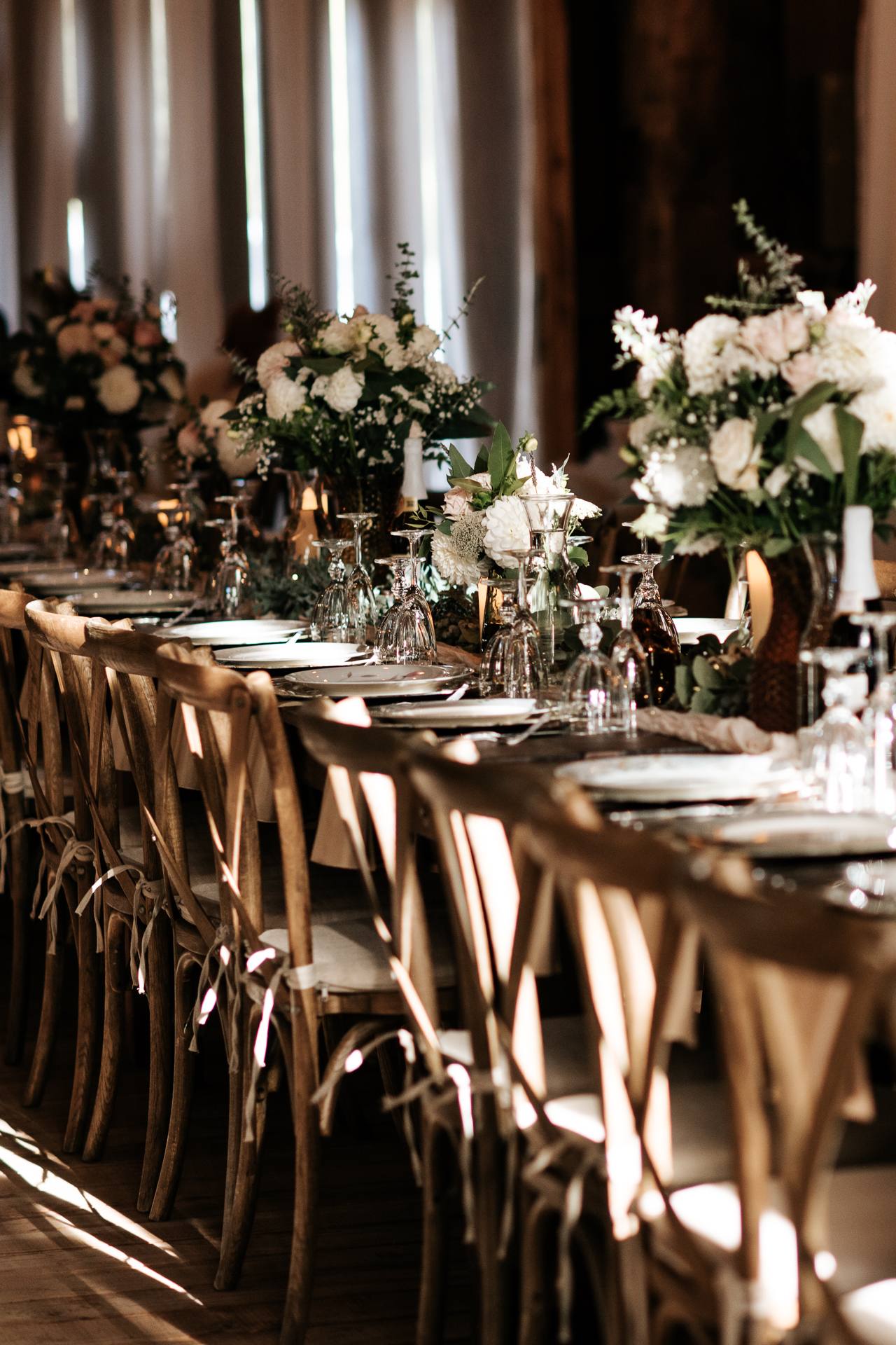 Elegant reception set up with glass wear and large flower arrangements 